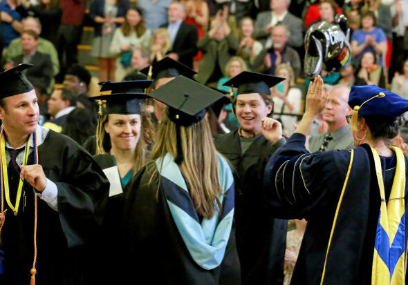 A procession of graduates receive congratulations from teachers as they file into the Diamond Physical Education Center during the commencement ceremony at Collage of Marin in Kentfield, Calif. Friday, May 20, 2016.(James Cacciatore/Special to the Marin Independent Journal)